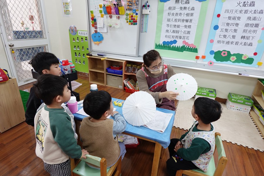 老師說明如何使用顏料彩繪紙傘