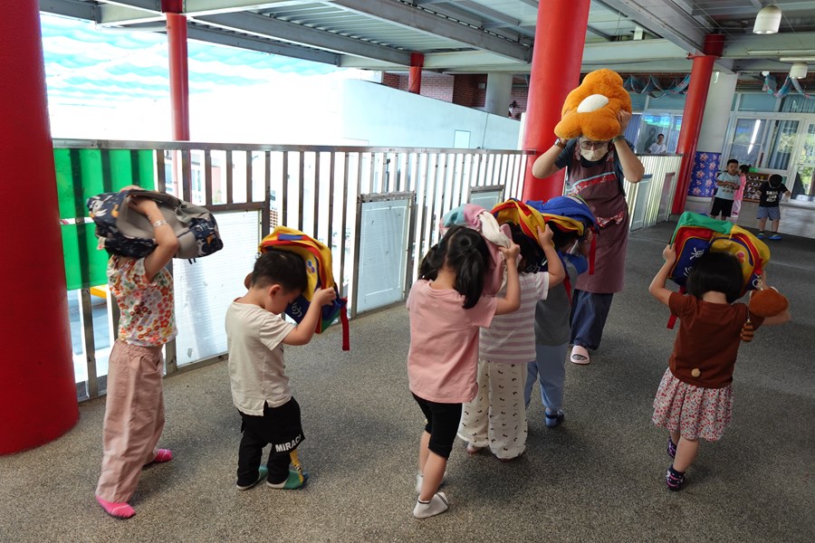 示範如何保護頭部，並往安全的地方逃生