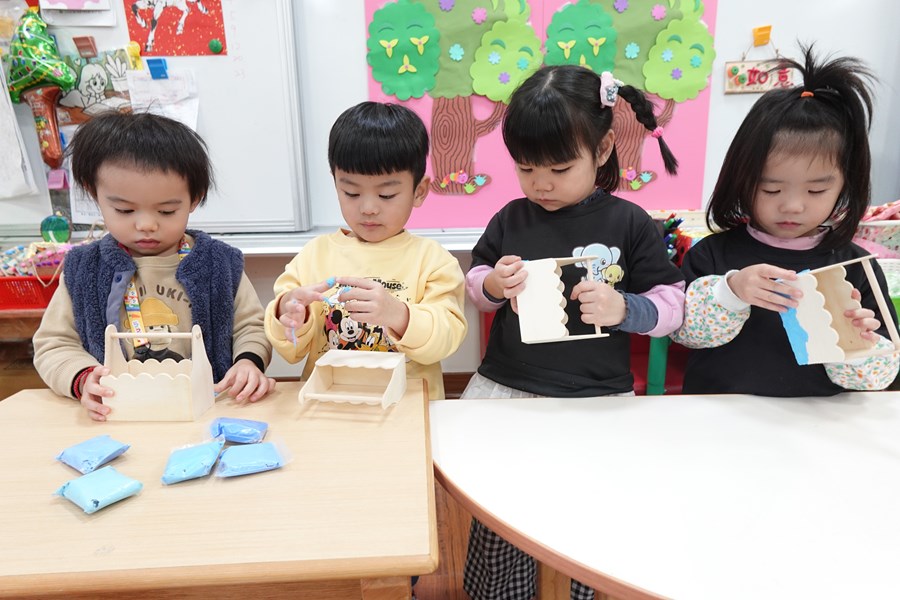 木盒上黏貼藍色的黏土，創作河水的效果